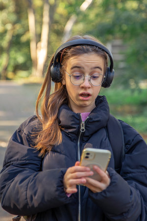 Surprised girl looks at the phone. Emotions concept.の写真素材