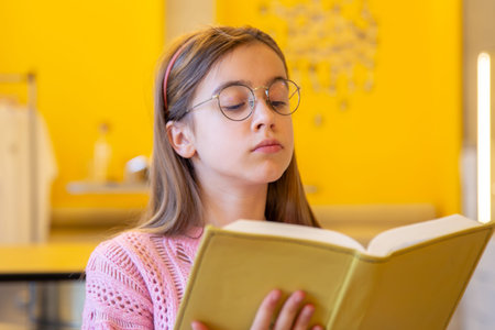 Serious teenage girl reading a book. Emotion concept.