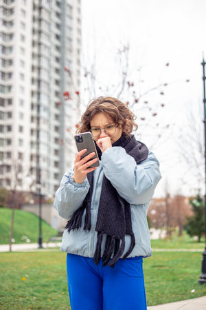 Young woman looking at phone in surprise in the city. A woman in a big city.の写真素材