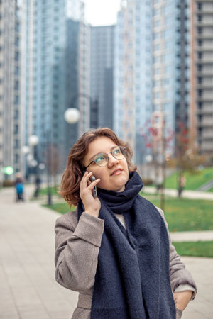 Cute teenage girl talking on the phone on the street. Girl in the city.の写真素材