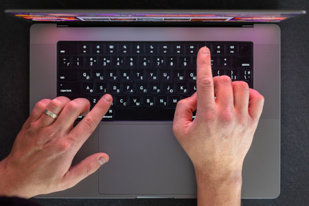 Male hands on laptop keyboard. Man typing on laptop. Top view.の写真素材