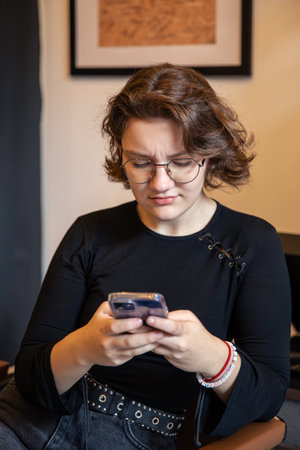 Busy and serious young woman with phone. Emotion and technology concept.の写真素材