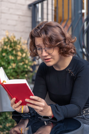 Tired and sleepy young woman reading a book. Emotion concept.の写真素材
