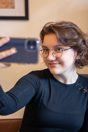Happy girl takes a selfie with her phone. Emotions concept.の写真素材