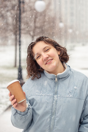 Portrait of a young woman in snowfall in the city. New year mood.の写真素材