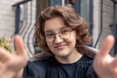 Happy girl stretches her hands to the camera. Emotion concept.の写真素材