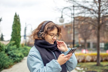 A teenage girl uses a phone in the city. Girl in the city. Technology concept.の写真素材