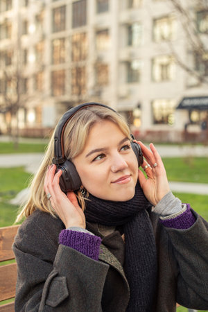 Attractive young woman listening to music on headphones in the city.の写真素材