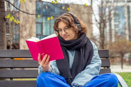 Girl reading a book on the street close-up. Teenage girl reading a book.の写真素材