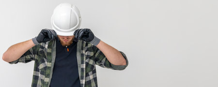 Portrait of a male builder. Engineer in overalls and helmet on a light background. Space for text.の写真素材