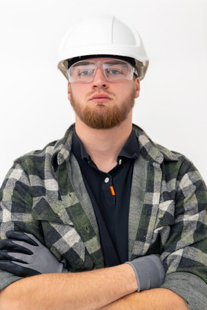 Portrait of a male builder. Engineer in overalls and helmet on a light background.の写真素材