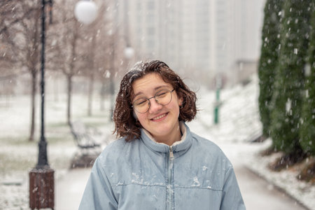 Portrait of a young woman in snowfall in the city. New year mood.の写真素材