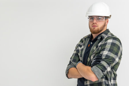 Portrait of a male builder. Engineer in overalls and helmet on a light background.の写真素材