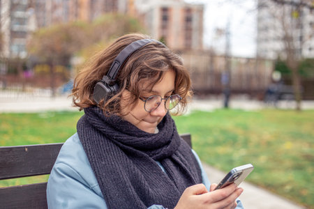 A teenage girl uses a phone in the city. Girl in the city.の写真素材