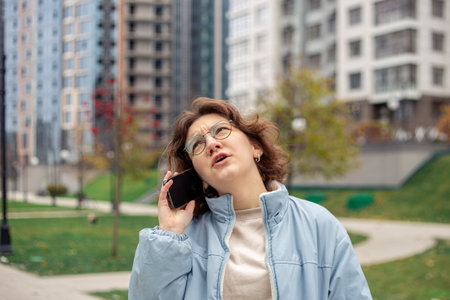 Young woman talking on the phone in the city.の写真素材