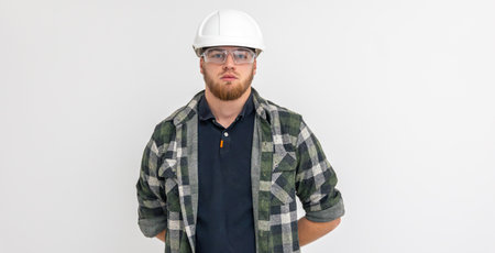 Portrait of a male builder. Engineer in overalls and helmet on a light background.の写真素材