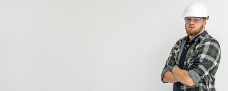 Portrait of a male builder. Engineer in overalls and helmet on a light background. Space for text.の写真素材