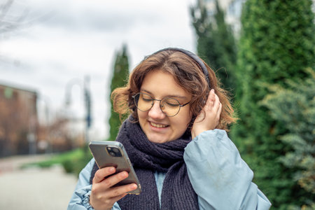 A teenage girl uses a phone in the city. Girl in the city.の写真素材