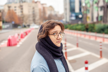 Young pretty woman walks on street across the road.