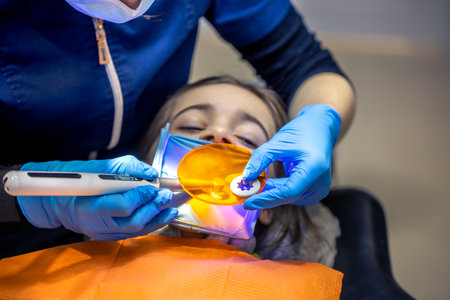 Dental fillings. Dental fillings with ultraviolet light. Female dentist treating a girls tooth.の写真素材