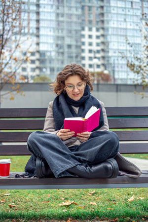 Girl reading a book on the street close-up. Teenage girl reading a book.の写真素材
