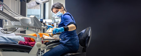 Young female dentist treating teeth of a girl in a dental office. Dentistry concept.の写真素材