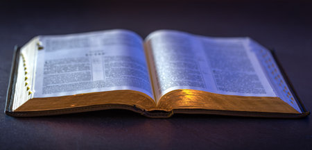 Open Holy Bible on the table. Religion concept. Bible on black background.の写真素材