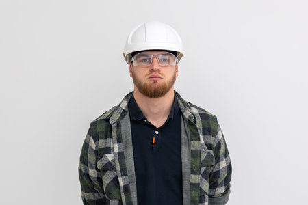Portrait of a male builder. Engineer in overalls and helmet on a light background.の写真素材