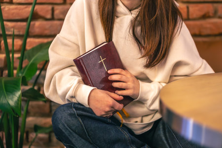 Woman holds a Bible in her hands. Religion concept. Bible close up.の写真素材