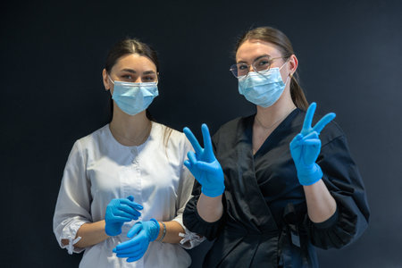 Female dentists in masks and gloves. Dentistry concept. Portrait of happy women.の写真素材