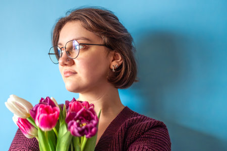 Young woman holding a bouquet of flowers in her hands. Womens Day. Valentines Day.の写真素材