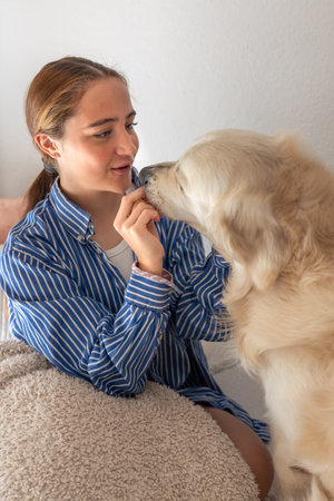 Cute teenage girl with a dog. Pet. Girl playing with her pet dog at home.の写真素材