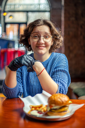 Young woman eating burger. Fast food. A woman in a burger restaurant.