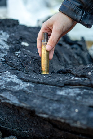 Woman holding rifle bullet shell in hand. War in Ukraine. Concept of war in Ukraine.