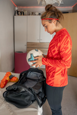 Sporty girl packing a bag for training. Sports girl going to training. Preparing for training.の写真素材