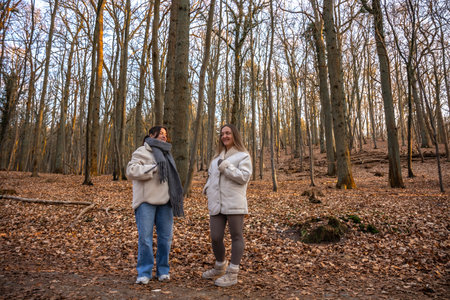 Two female friends on a walk in the forest. Friends walking through the forest. People in nature.の写真素材