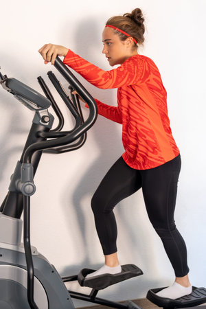 Sporty girl training on a treadmill at home. Home workout.