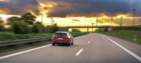 Car speeding on highway. Motion at sunset. Road trip scene.