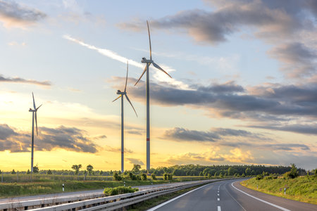 Wind turbines at sunset. Road and clean energyの写真素材