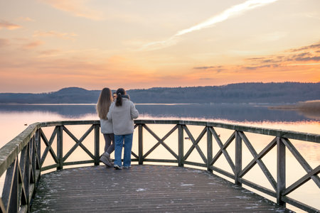 Friends watching the sunset on the lake. Sunset. Walking in nature. Pier. Berth.の写真素材