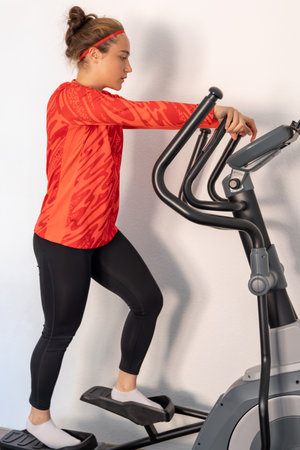 Sporty girl training on a treadmill at home. Home workout. Treadmill.の写真素材