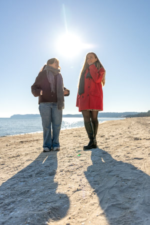 Two women walking on the seashore. Two friends spending time together. Sea.の写真素材