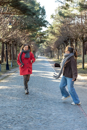 Two women walking in the park. Friends walking on a path in the park. Nature.の写真素材