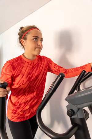Sporty girl training on a treadmill at home. Home workout. Treadmill.の写真素材