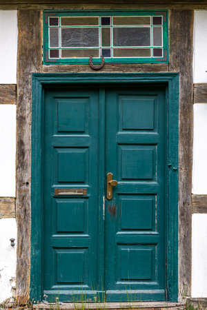 Teal vintage door. Scandinavian wooden facade. Brass handle and mail slot.の写真素材