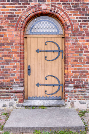 Church wooden doors. Antique wrought iron. Brick archway.の写真素材