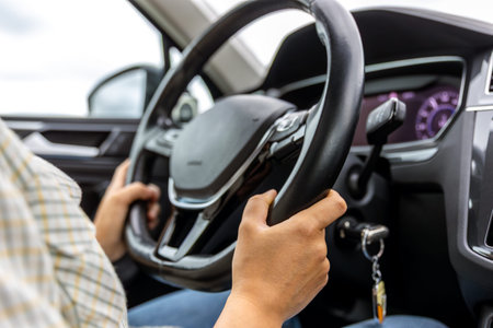 Driver at steering wheel. Hands on car wheel. Modern vehicle interior