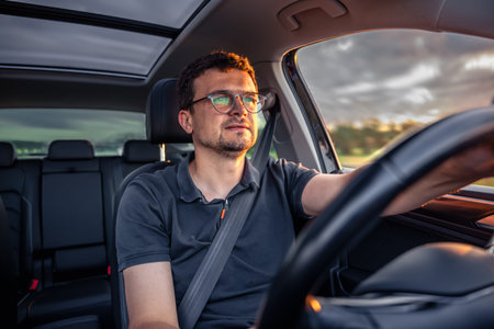 Driver in motion. Focused look. Sunset car interior