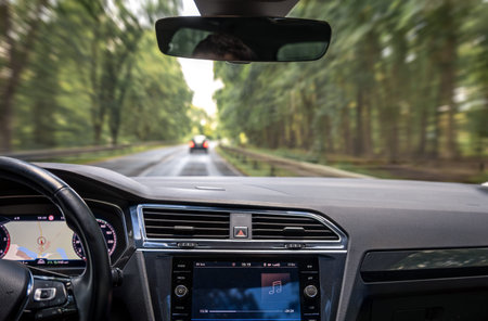 Car interior in motion. Music on dashboard. Forest highway view.