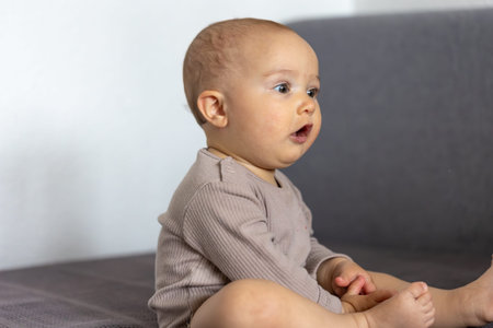 Surprised baby looking sideways. Honest reaction. Childhood emotion